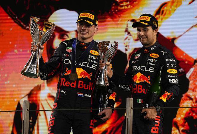 Red Bull’s Max Verstappen (left) celebrates with the trophy on the podium after winning the 2022 Abu Dhabi Grand Prix alongside third placed Red Bull’s Sergio Perez (right).