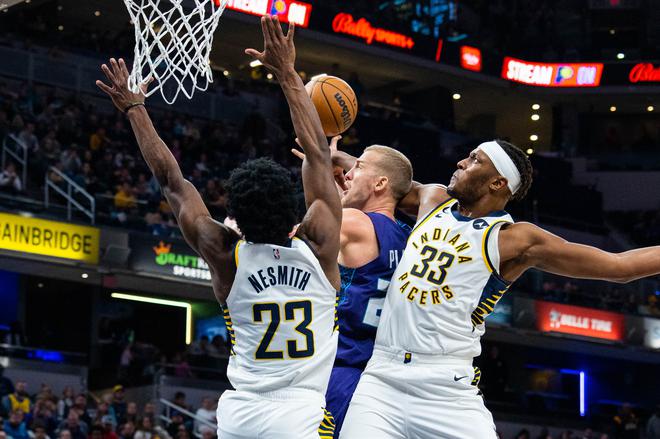 Charlotte Hornets center Mason Plumlee (24) shoots the ball while Indiana Pacers forward Aaron Nesmith (23) and center Myles Turner (33) defend in the second half at Gainbridge Fieldhouse.